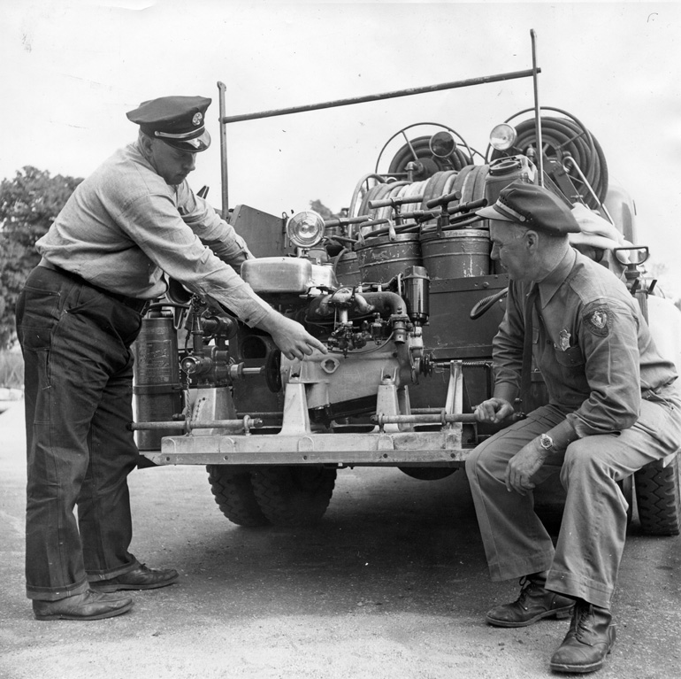 Chief Allan Kidder (left) and District State Warden Arthur Halenborg instpect new equipment 
on the rear of the 1941 Forest Fire Service Truck